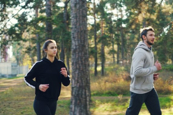 Man and woman jogging together in a park.